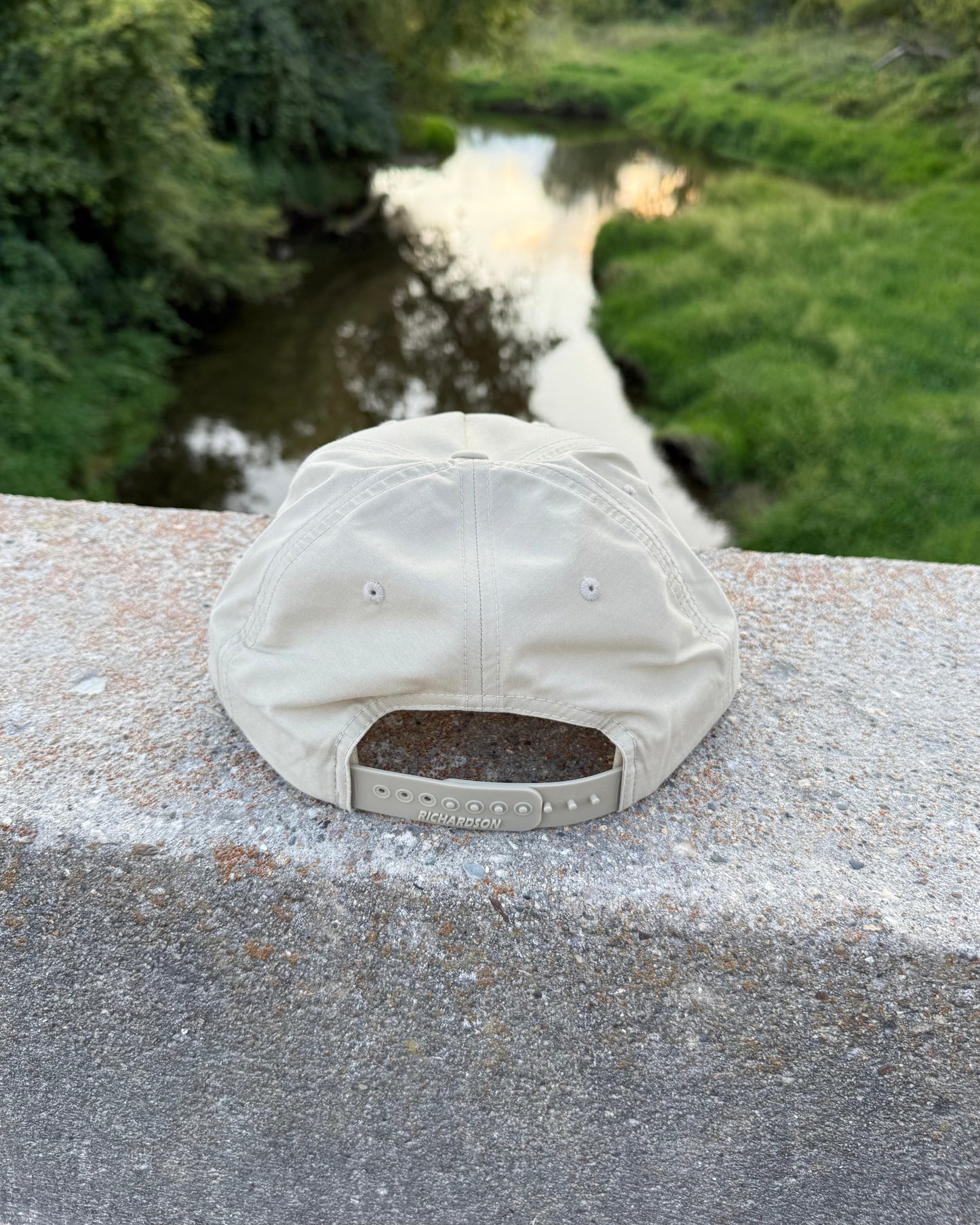 White cap on a concrete ledge with a blurred natural background