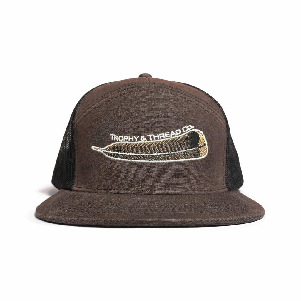 Brown cap with black mesh back and embroidered turkey feather logo on a white background